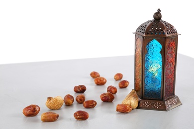 Photo of Muslim lantern and dates on table against white background