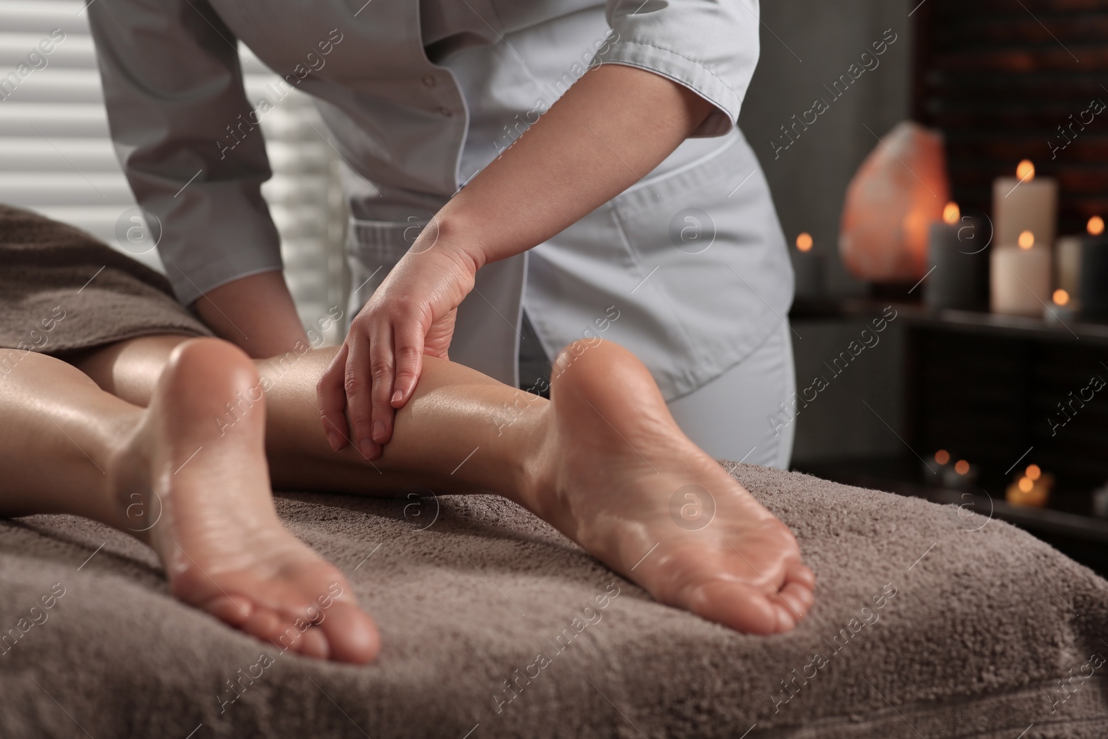 Photo of Woman receiving leg massage in spa salon, closeup