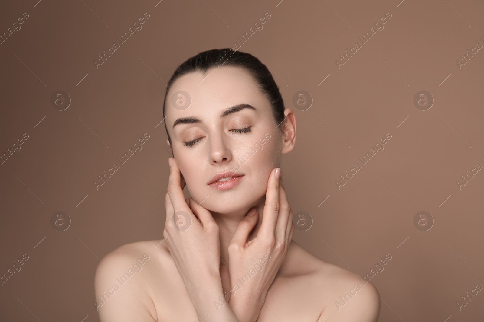 Photo of Portrait of beautiful young woman on brown background