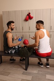 Handsome athletic men talking in locker room