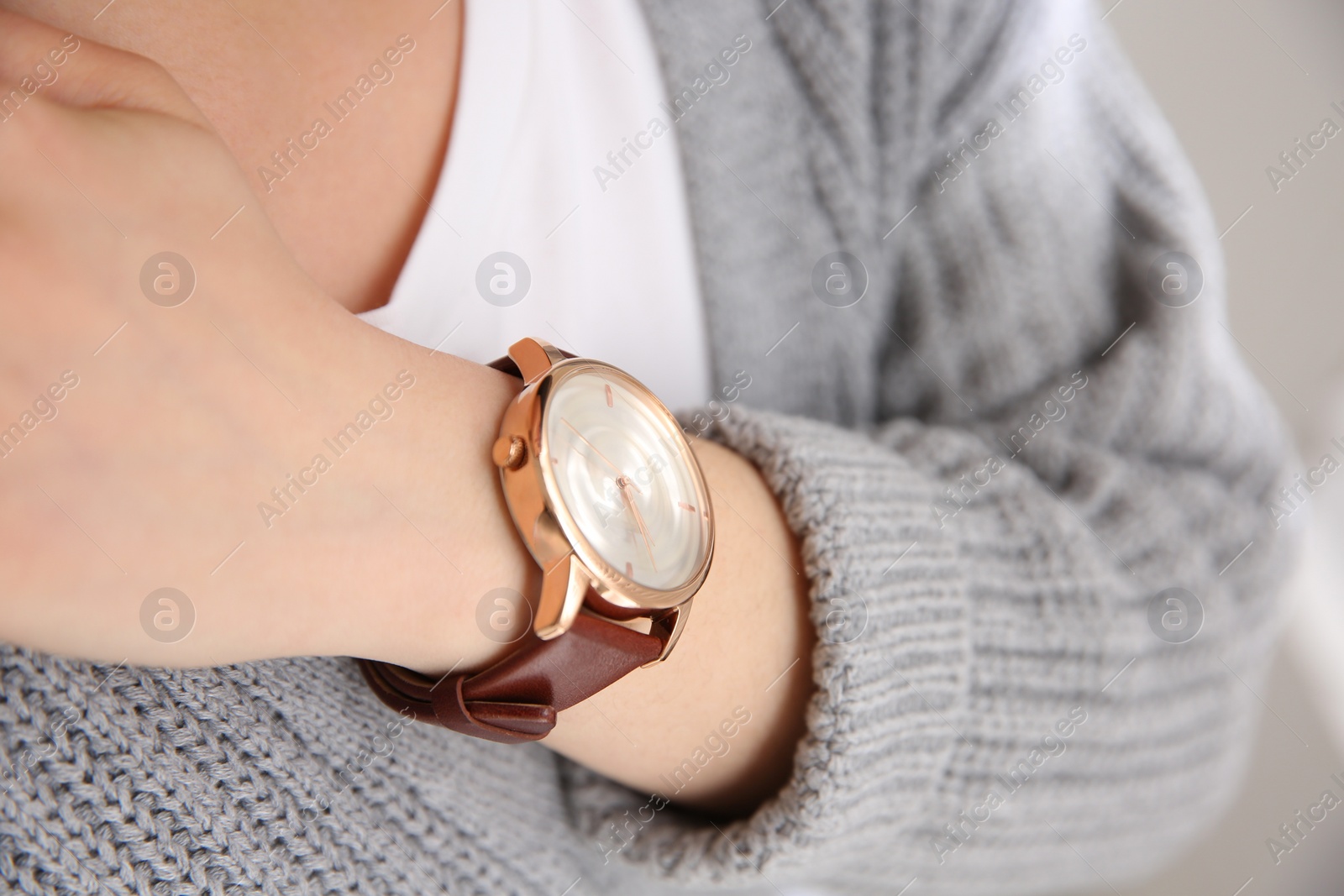 Photo of Woman with luxury wristwatch on blurred background, closeup