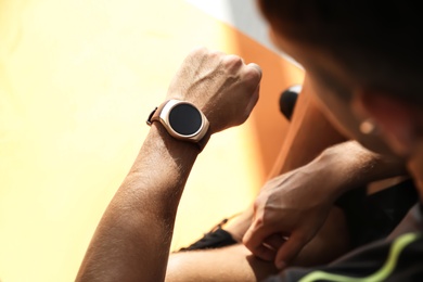 Photo of Man checking fitness tracker in gym, closeup