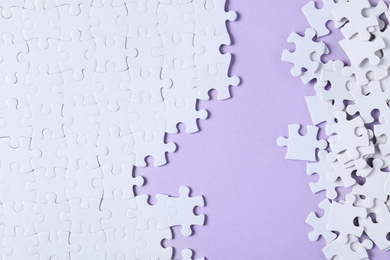 Photo of Blank white puzzle pieces on violet background, flat lay