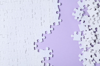 Blank white puzzle pieces on violet background, flat lay