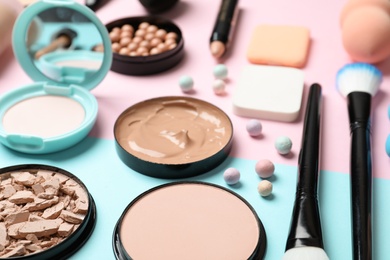 Composition with powder, skin foundation and beauty accessories on color background