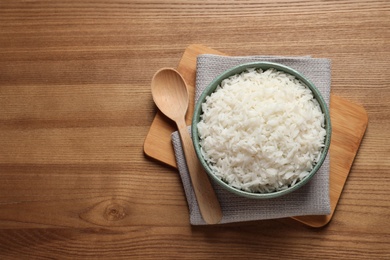 Bowl of tasty cooked rice served on table, flat lay. Space for text