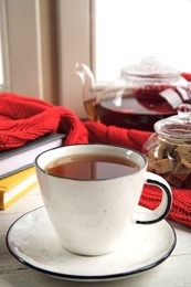 Photo of Cup of hot tea on window sill. Winter drink