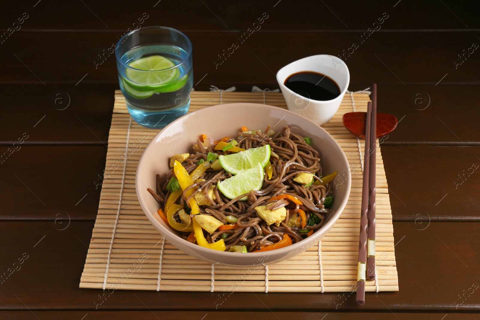 Photo of Stir-fry. Delicious cooked noodles with chicken and vegetables in bowl served on wooden table