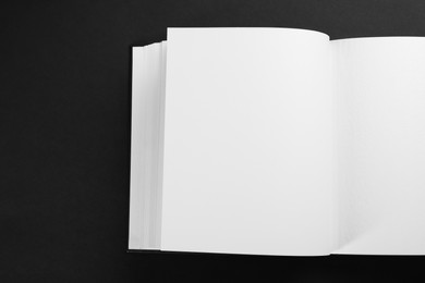 Photo of One open photo album on black background, top view. Space for text