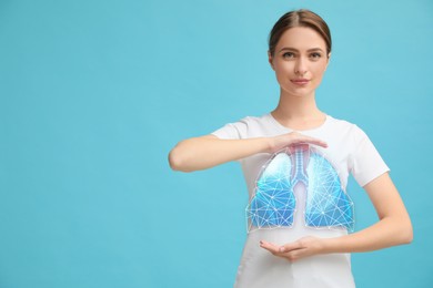 Image of Young woman holding hands near chest with illustration of lungs on turquoise background, closeup. Space for text