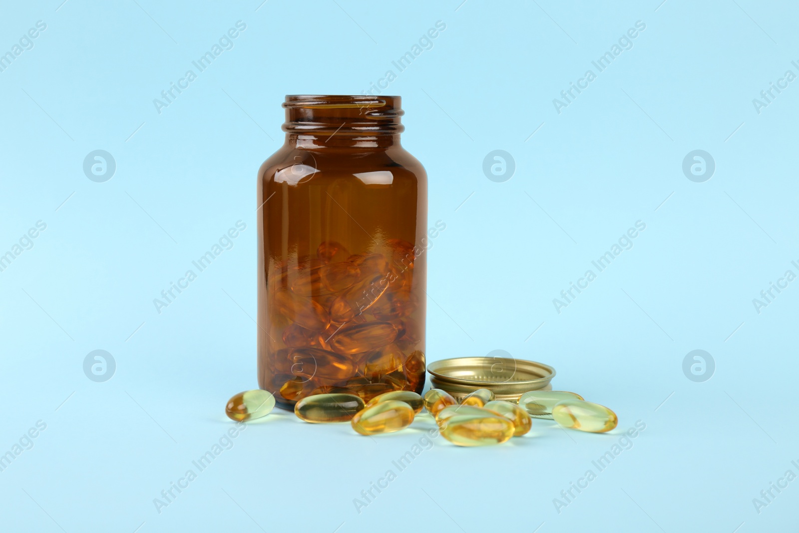 Photo of Jar with vitamin capsules on light blue background