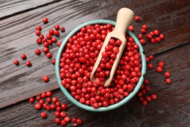 Photo of Aromatic spice. Red pepper in bowl and scoop on wooden table, top view