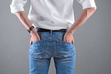 Photo of Man in stylish blue jeans on grey background