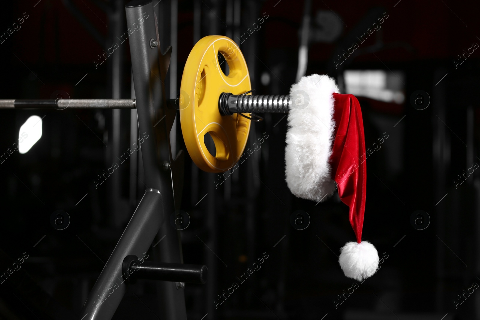 Photo of Santa Claus hat on barbell in gym