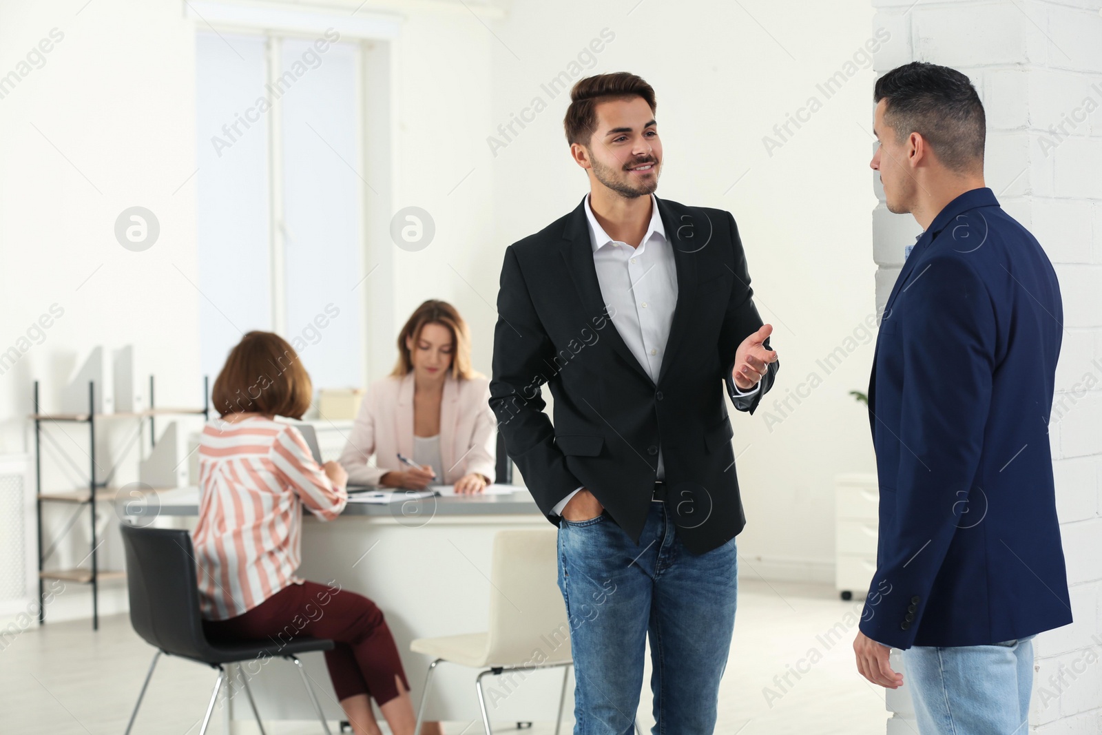 Photo of Human resources manager speaking with applicant before job interview in office