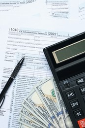Photo of Calculator, pen and money on documents, flat lay. Tax accounting