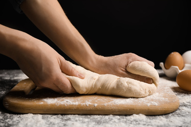 Photo of Woman with dough at grey table, closeup. Making pasta