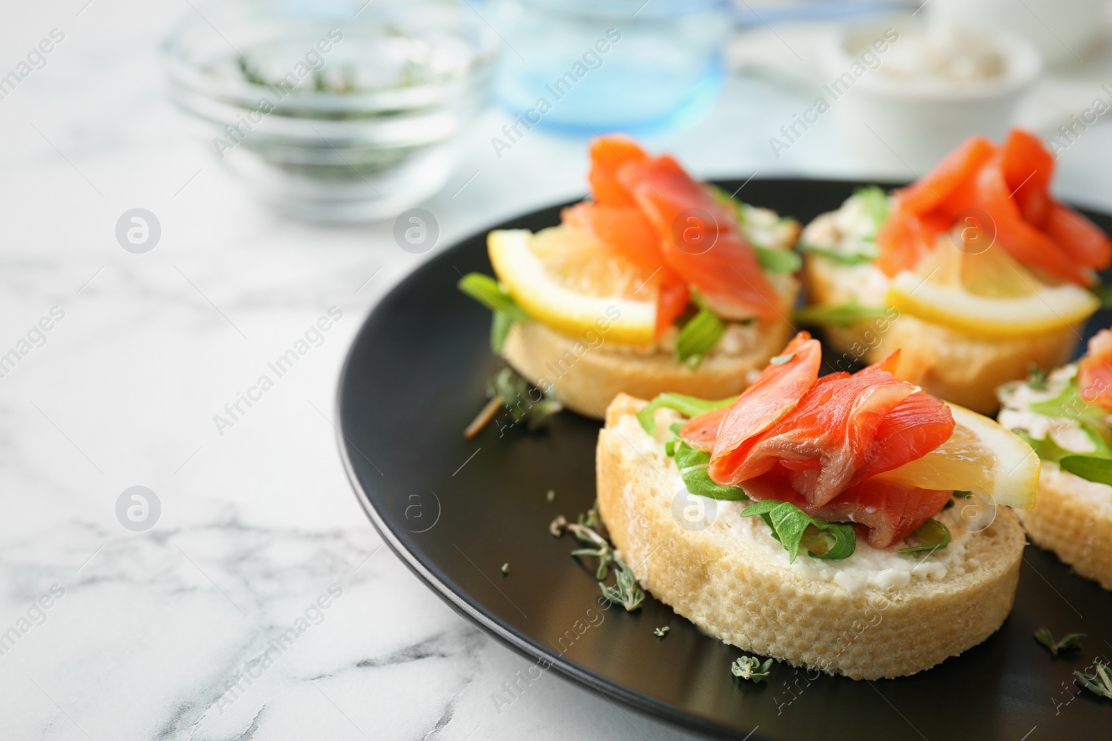 Photo of Tasty sandwiches with fresh sliced salmon fillet on plate, closeup