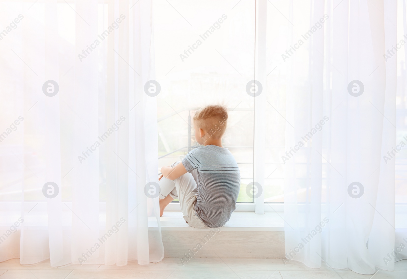 Photo of Little boy sitting near window. Autism concept