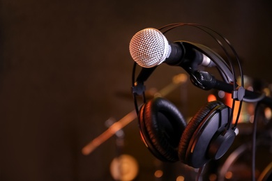 Photo of Condenser microphone and headset in modern recording studio. Space for text