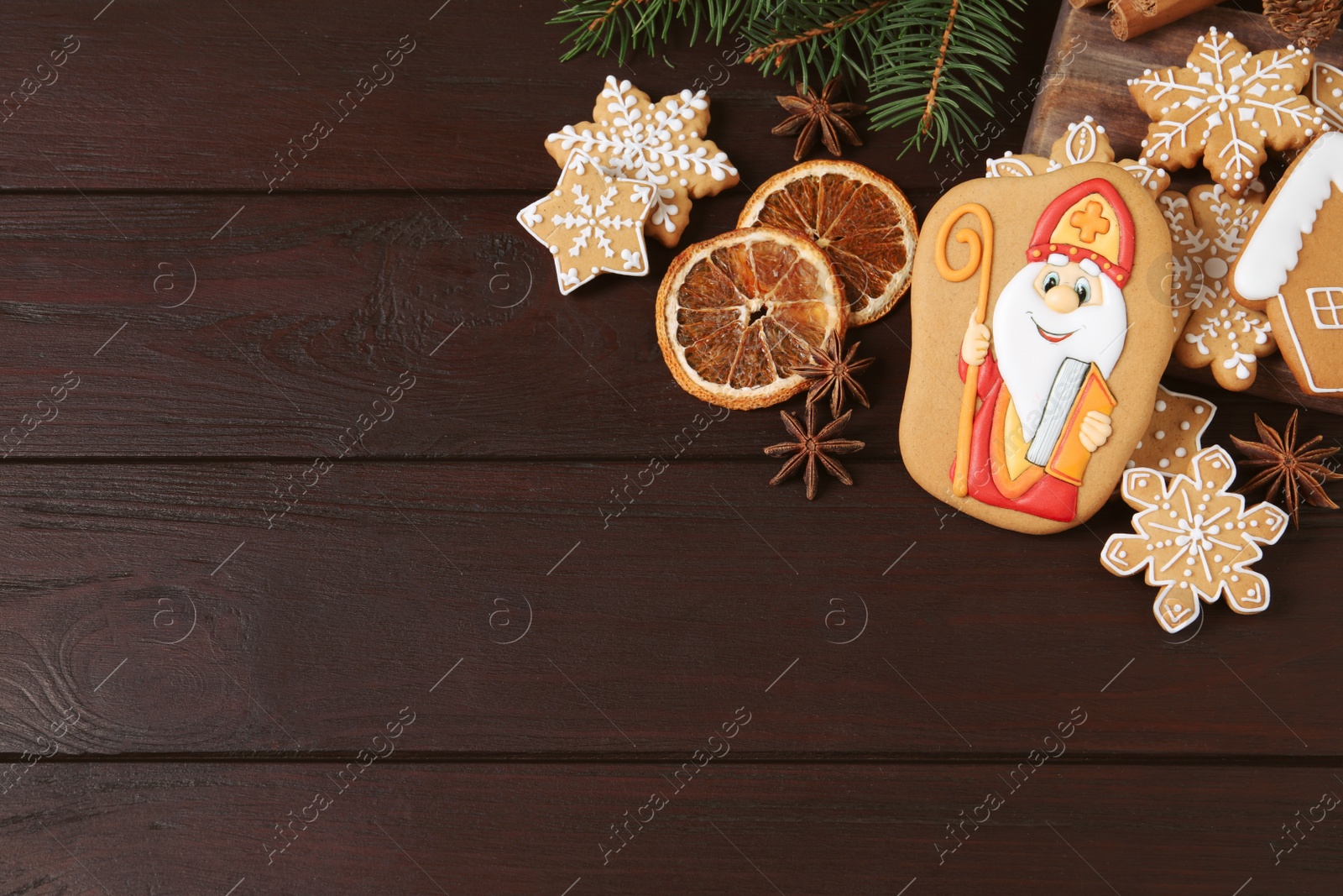 Photo of Tasty gingerbread cookies on wooden table, flat lay with space for text. St. Nicholas Day celebration