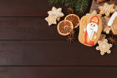 Photo of Tasty gingerbread cookies on wooden table, flat lay with space for text. St. Nicholas Day celebration