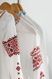 Photo of Beautiful shirts with different embroidery designs on white background. Ukrainian national clothes