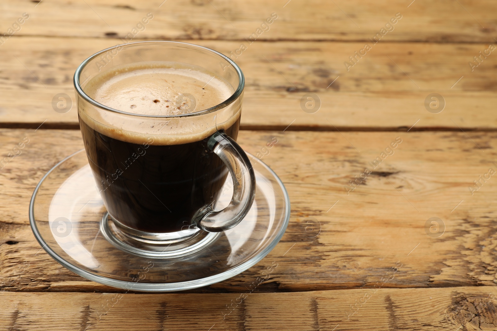 Photo of Cup of aromatic coffee on wooden table, closeup. Space for text