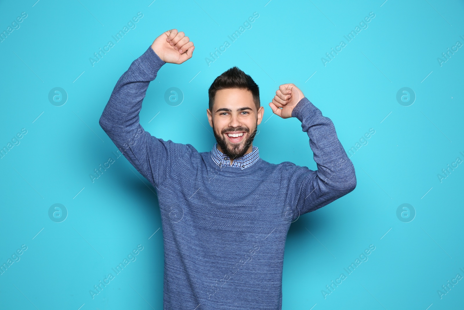 Photo of Happy young man celebrating victory on color background