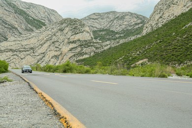 Photo of Beautiful view of car on asphalt highway in mountains. Road trip