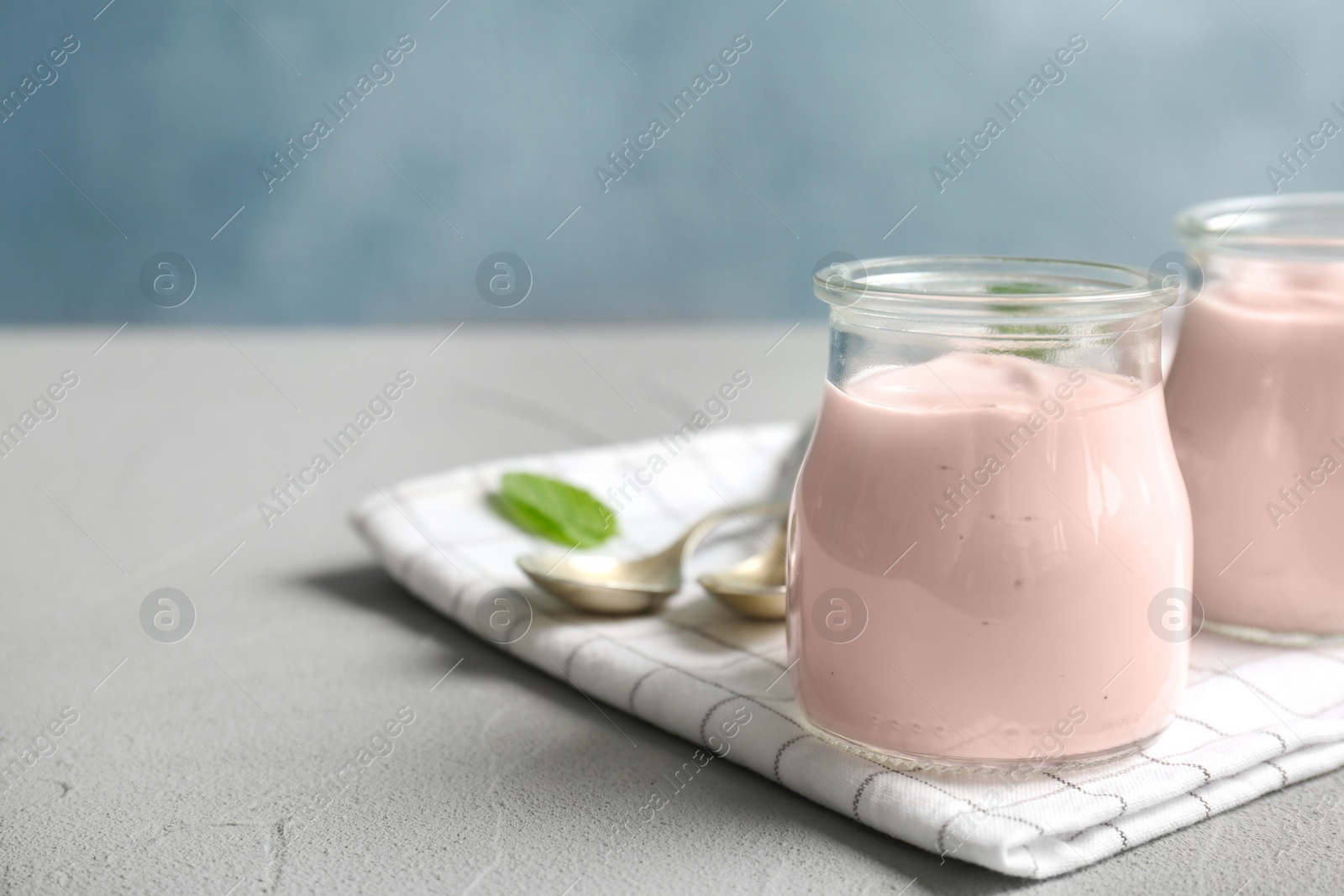 Photo of Jars with yummy yogurt on table