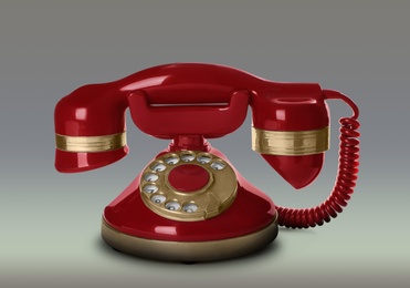 Image of Vintage red corded telephone on light grey background