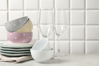 Photo of Beautiful ceramic dishware and glasses on light grey table, space for text