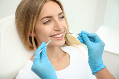 Photo of Doctor examining patient's teeth in clinic, closeup. Cosmetic dentistry