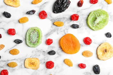 Photo of Flat lay composition with different dried fruits on marble background. Healthy lifestyle