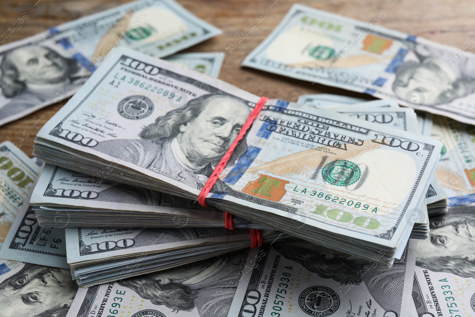 Photo of Many dollar banknotes on wooden table, closeup. American national currency