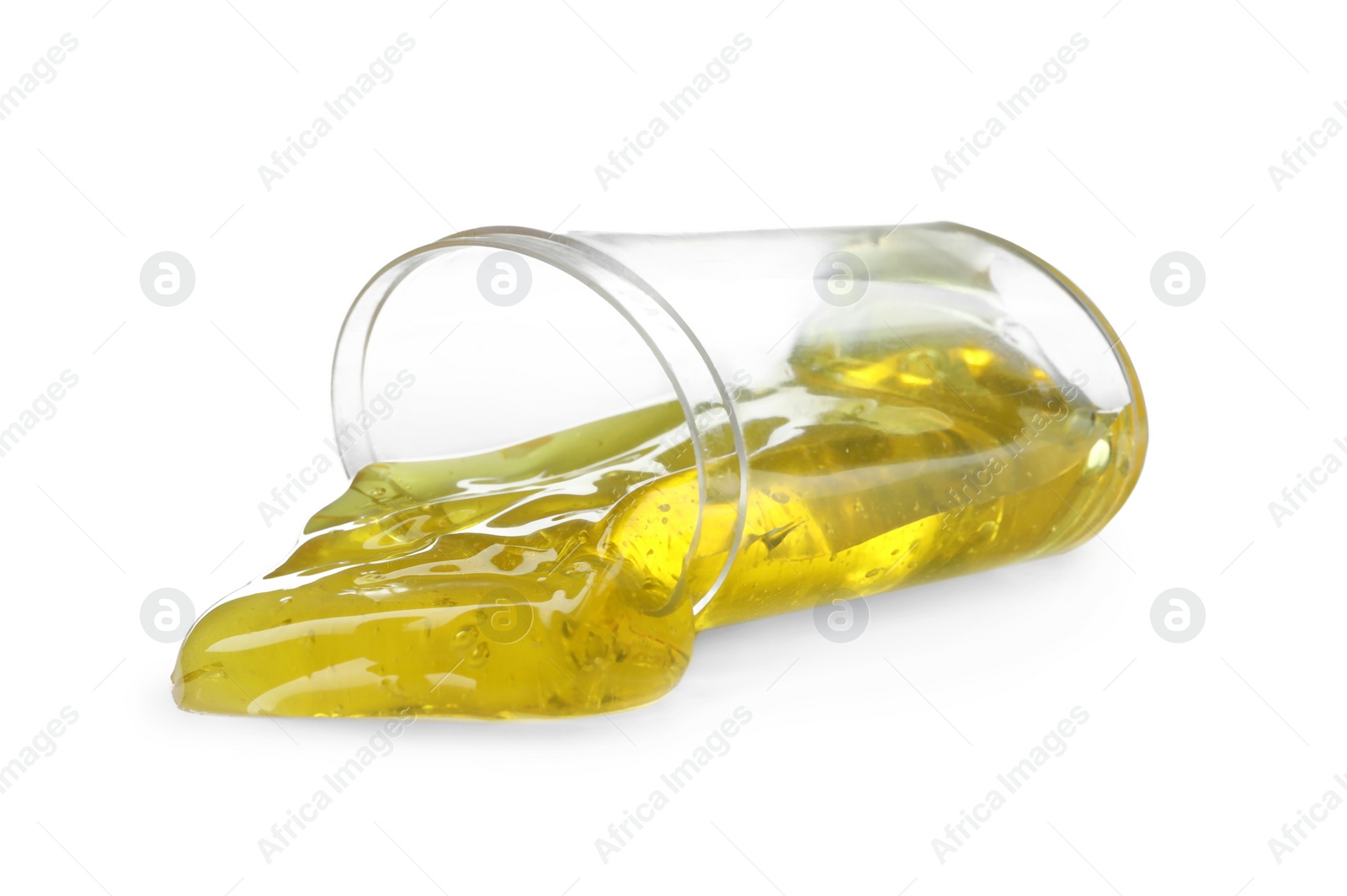 Photo of Overturned plastic container with yellow slime isolated on white. Antistress toy