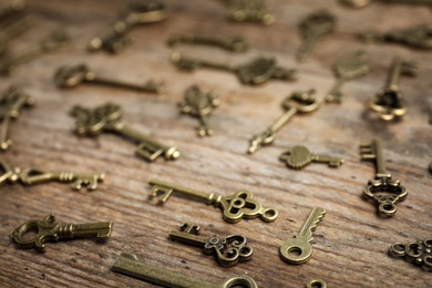 Old vintage keys on wooden background, closeup
