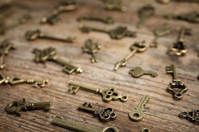 Photo of Old vintage keys on wooden background, closeup