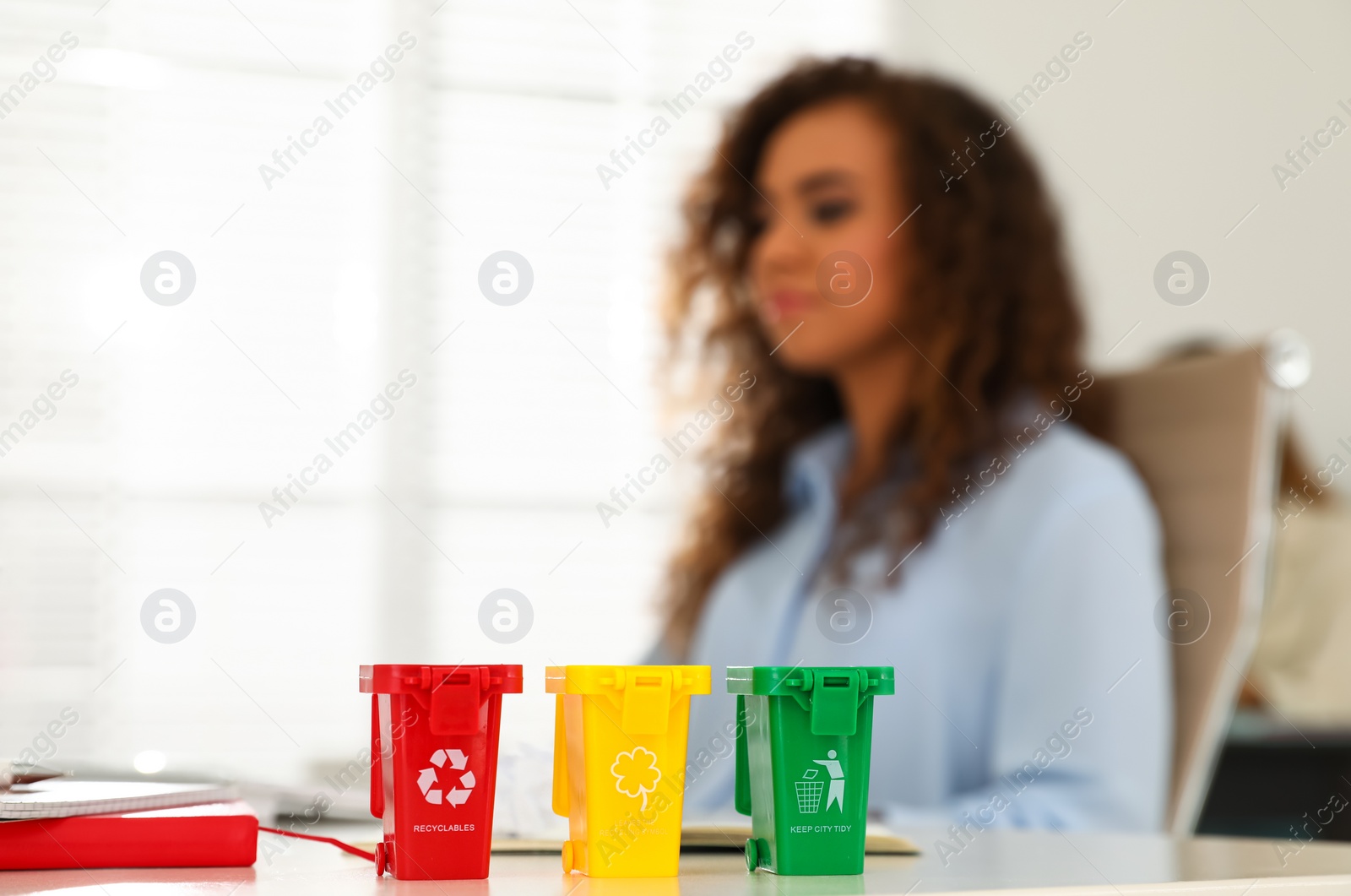 Photo of Mini recycling bins on table in office