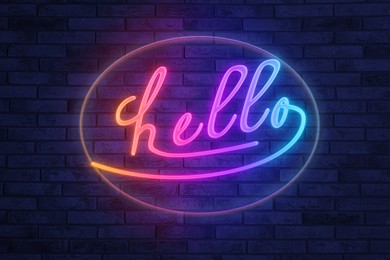 Image of Stylish neon sign with word Hello on brick wall