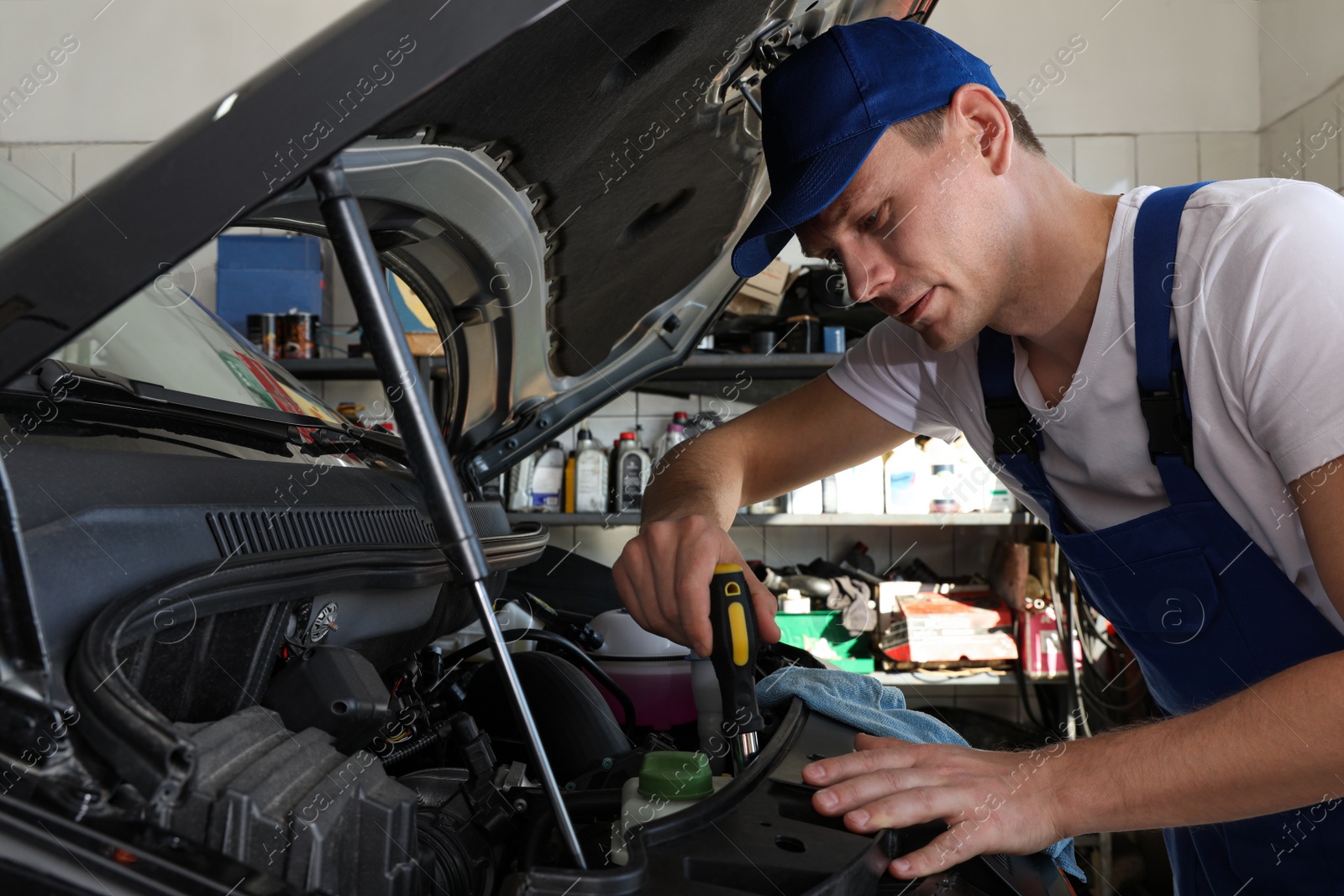 Photo of Professional auto mechanic fixing modern car in service center