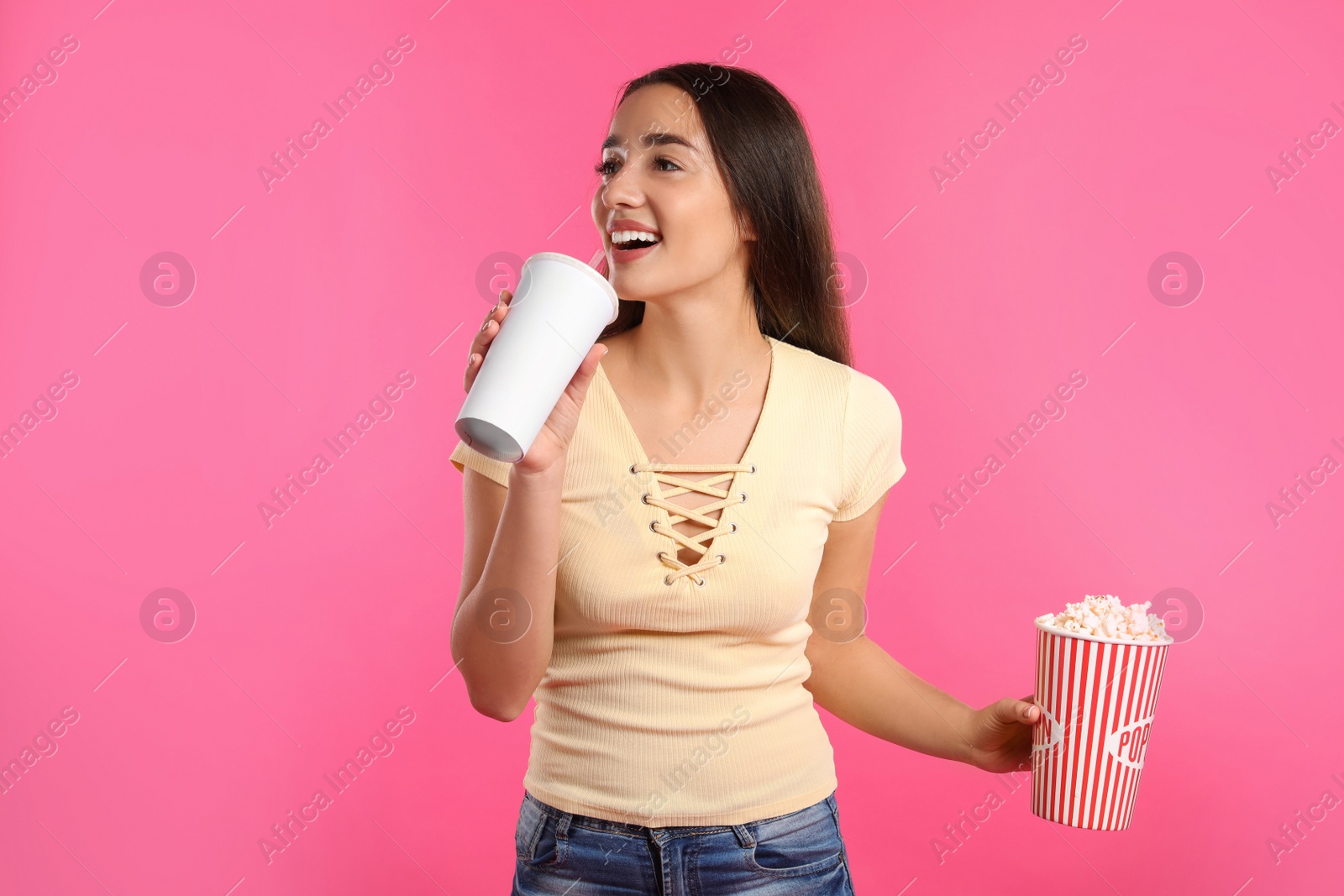 Photo of Woman with popcorn and beverage during cinema show on color background