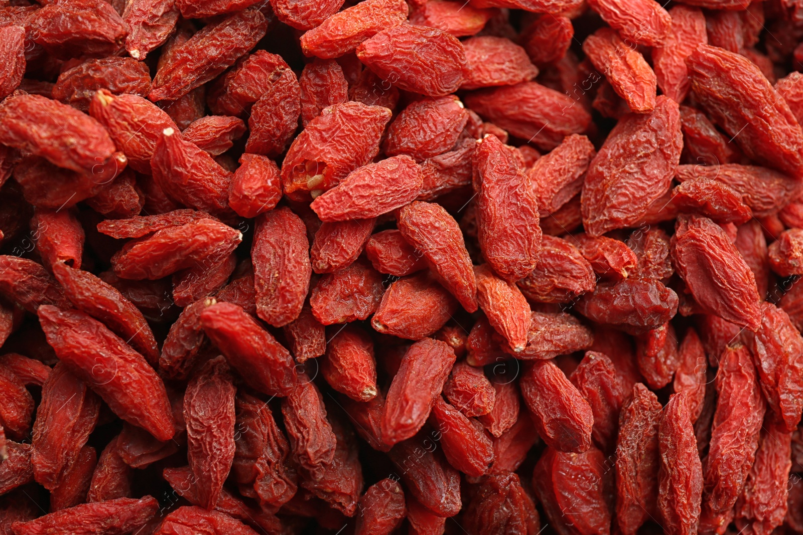 Photo of Many dried goji berries as background, closeup. Healthy superfood