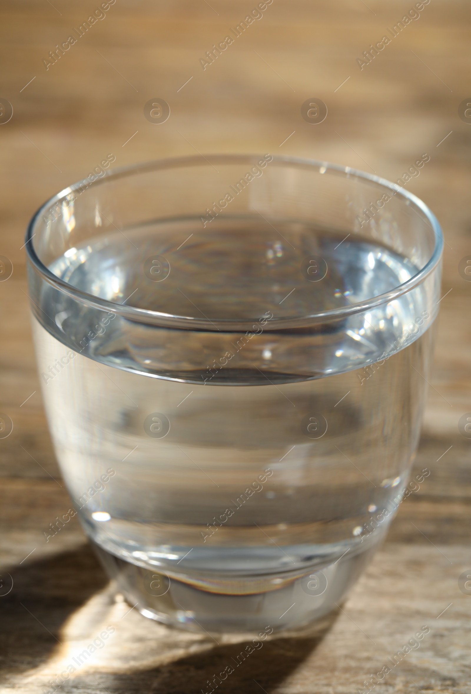 Photo of Glass of water on wooden table, closeup. Refreshing drink