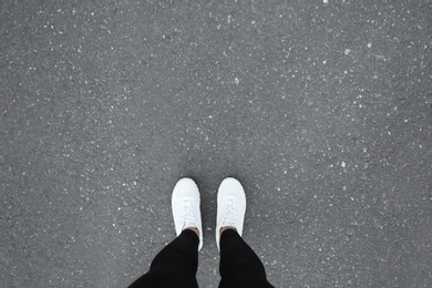 Photo of Woman standing on asphalt road, top view. Space for text