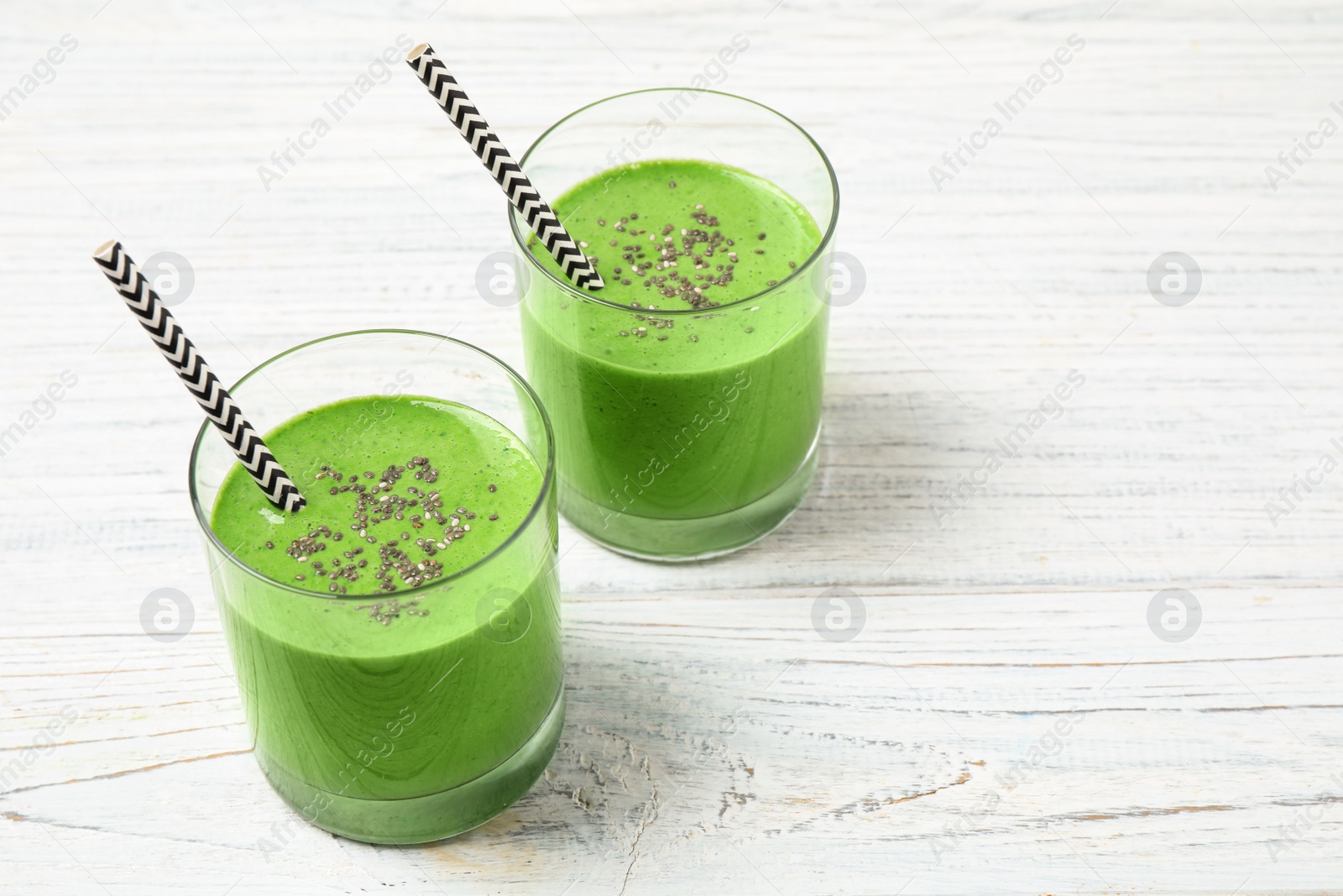 Photo of Tasty kale smoothie on white wooden table