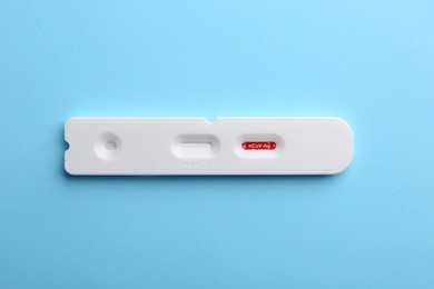 Photo of Disposable Covid-19 express test on light blue background, top view