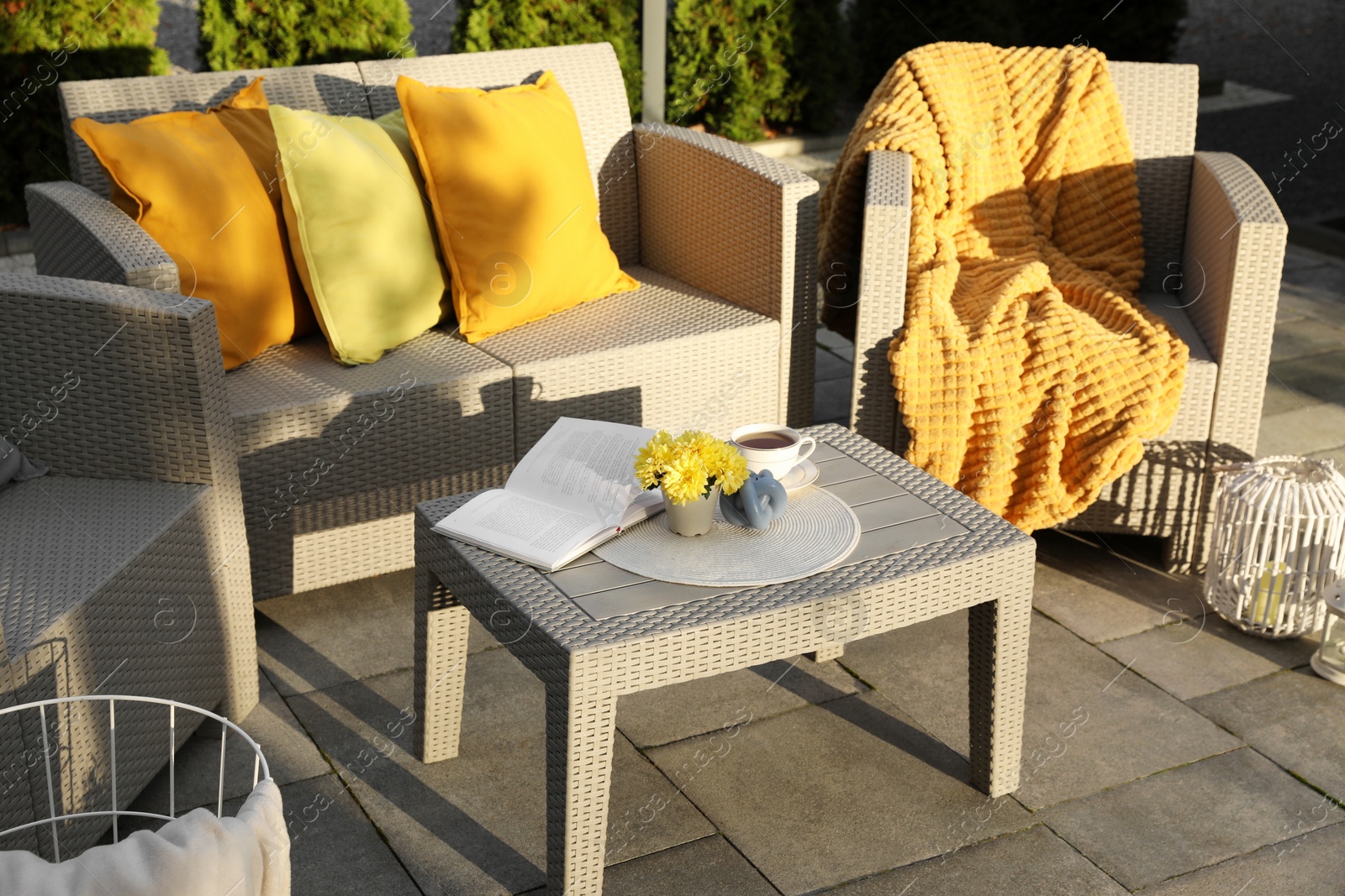 Photo of Beautiful rattan garden furniture, soft pillows and different decor elements outdoors