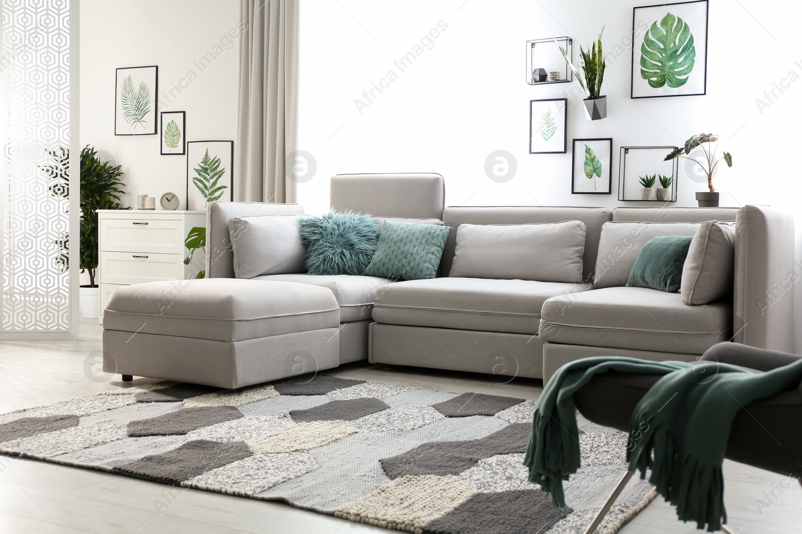 Photo of Comfortable large sofa in light room. Interior design